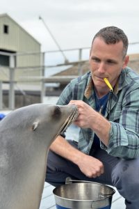 Portrait of Dr. Cook with handling a seal.